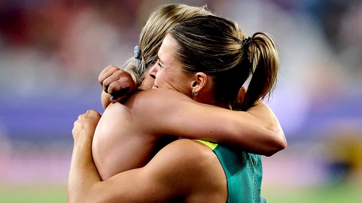 two women hug after tying for first place in the pole vault
