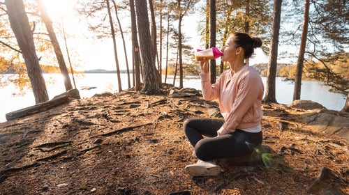 woman drinking protein powder outdoors