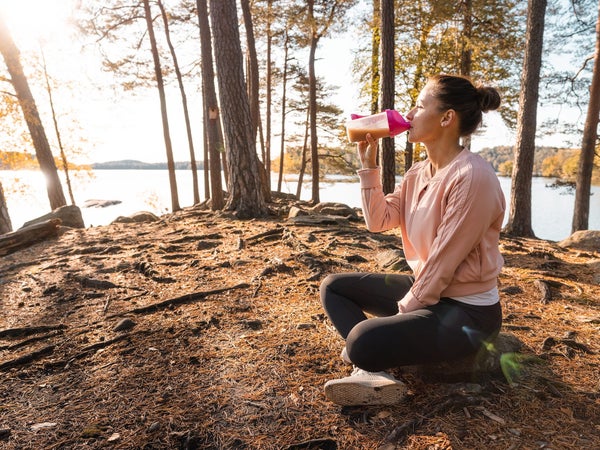 woman drinking protein powder outdoors