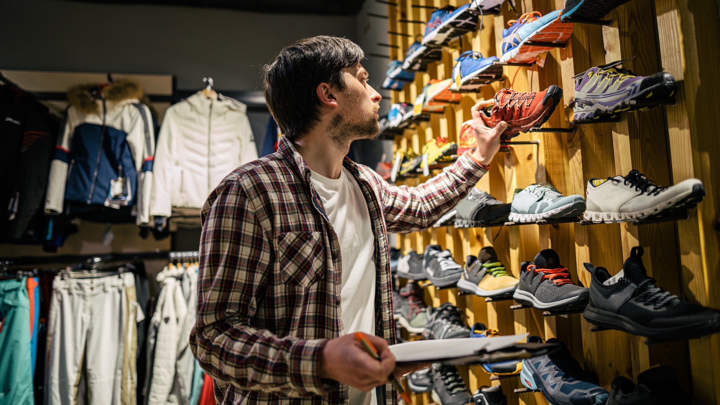Sales assistant sports travel store makes inventory running shoes.