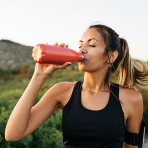 Woman hydrates after finishing a workout outside