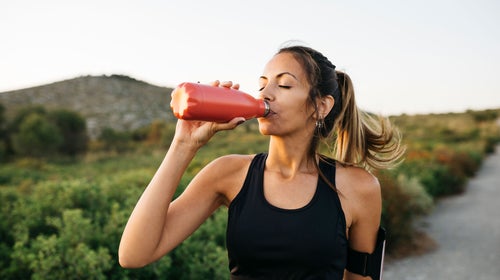 Woman hydrates after finishing a workout outside