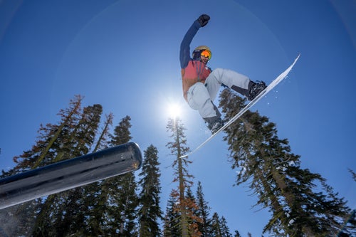 Man snowboarding in a terrain park going off a feature