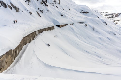 Man wiping out on a big drop on a snowboard