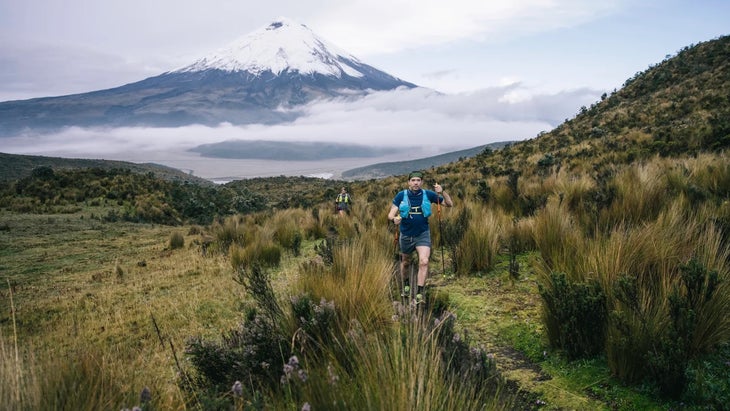 runners hike in front of a volcano in Ecuador