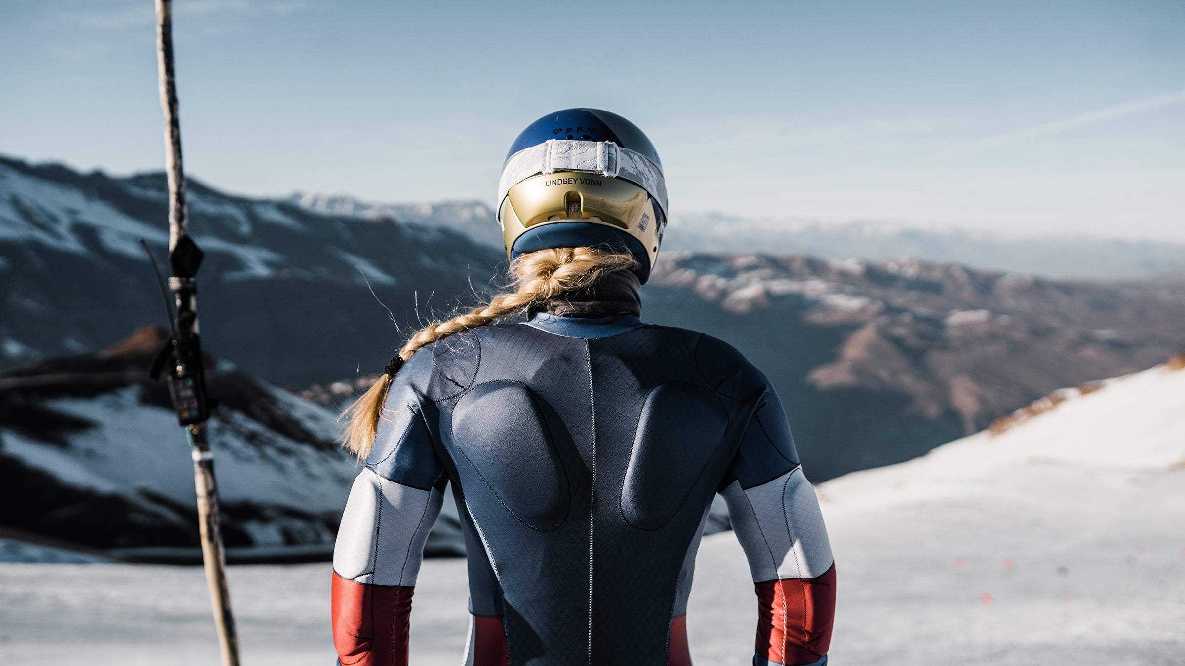 The back of Lindsey Vonn as she stares down a mountain.