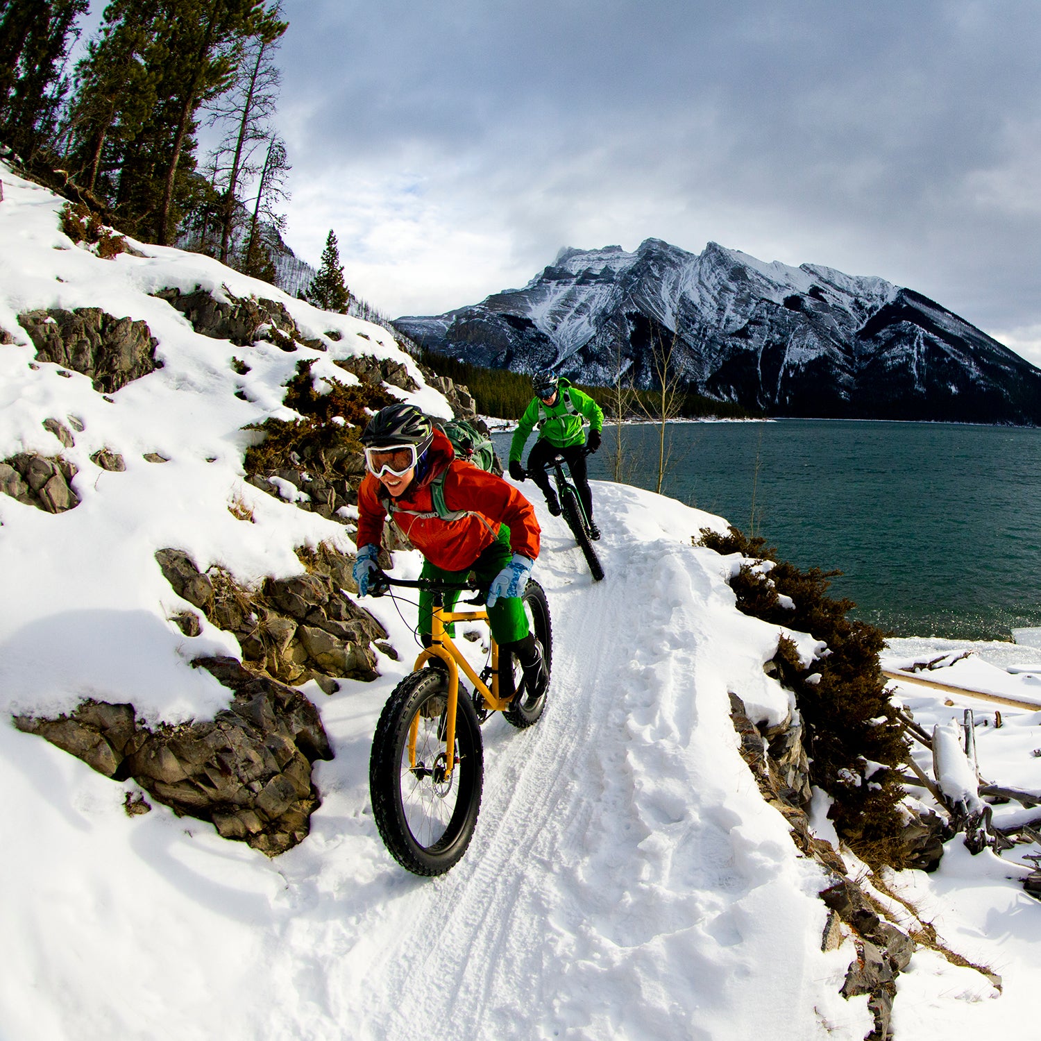 A woman and man enjoy a winter fat bike ride in Banff National Park, Alberta, Canada.