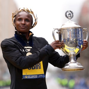 a woman poses with a trophy