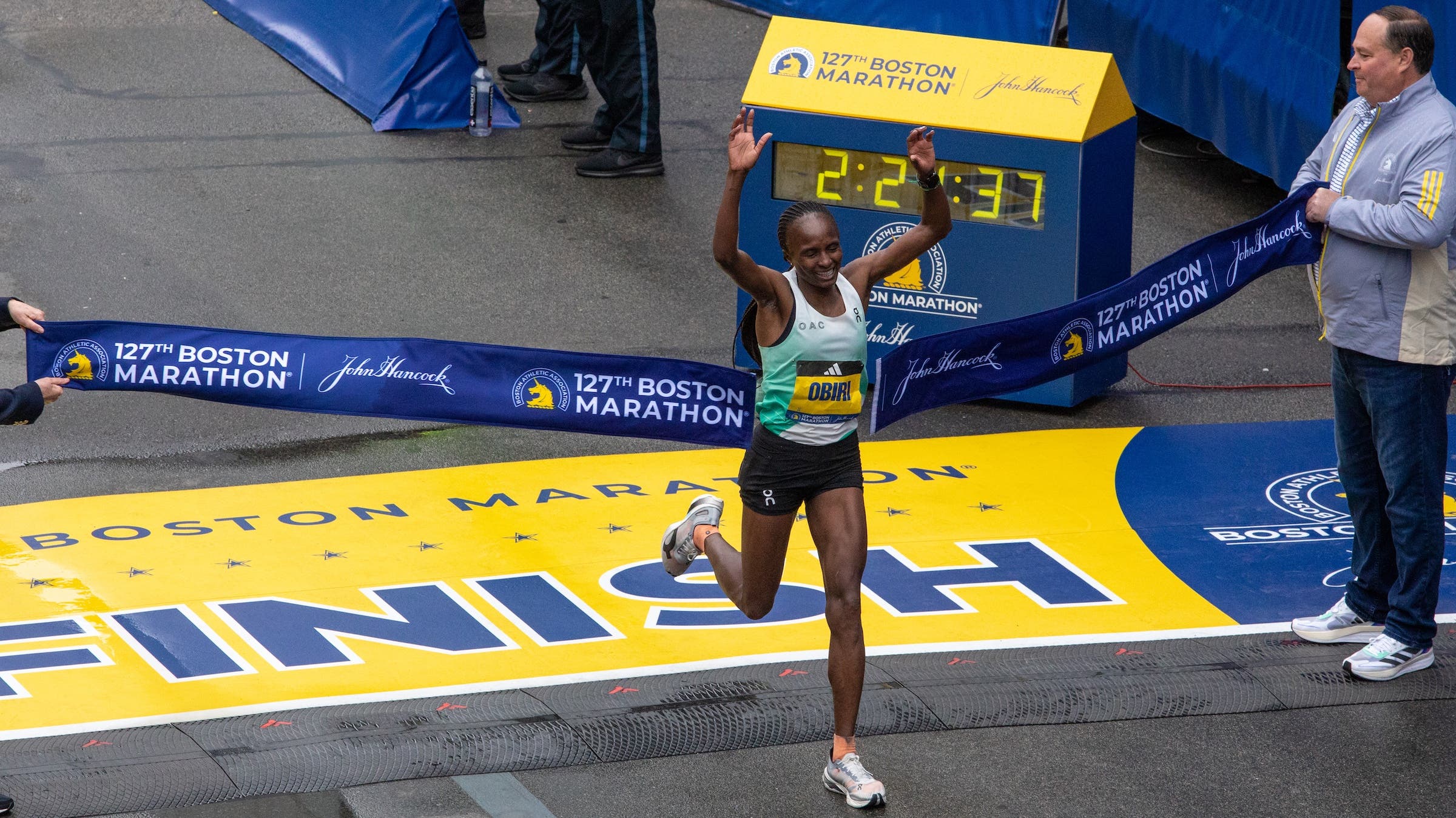a woman crosses the boston marathon in first