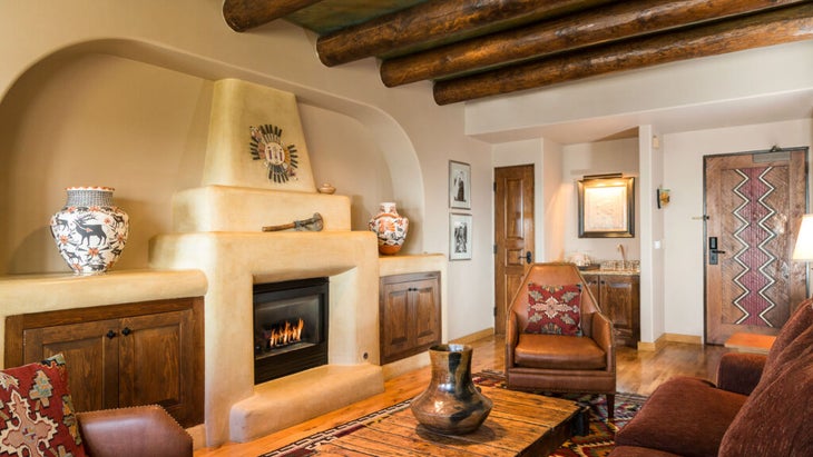 A suite at Hotel Santa Fe, with a fireplace and wooden beams and Native artwork