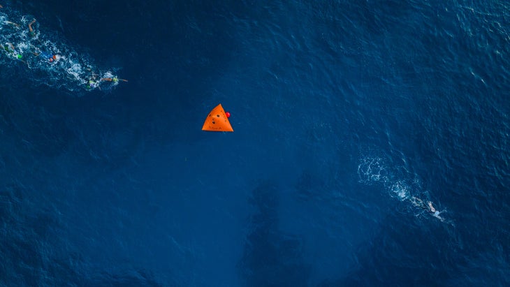 Swimmers in the water with an orange bouy