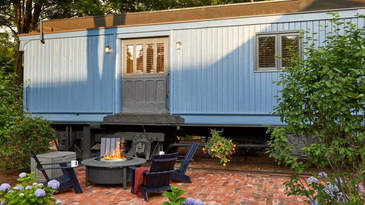 The Kent Collection’s blue boxcar, with a fire pit outside