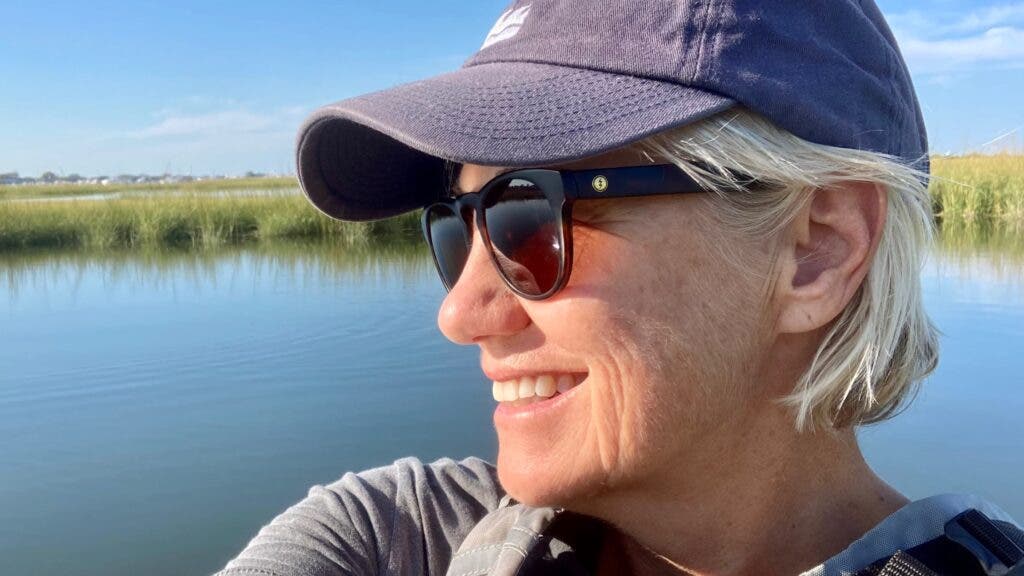 A profile of the author wearing a ball cap and sunglasses looking out at the coastline of Nantucket, Massachusetts