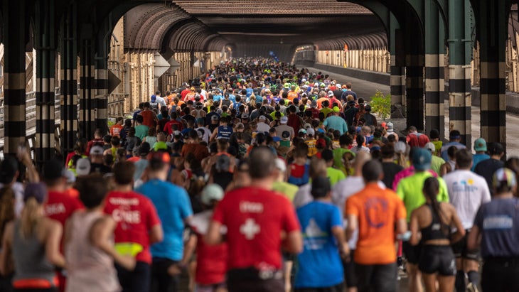 A group of marathoners follows a tunnel 