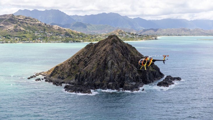 A helicopter buzzes by an islet off Oahu