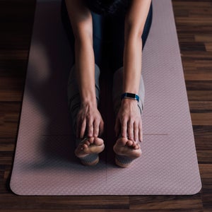 An Anonymous Young Woman Stretching Arms and Legs at Home