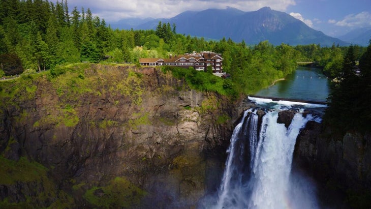 The Salish Lodge overlooking its tall falls, with a background of forest and mountains