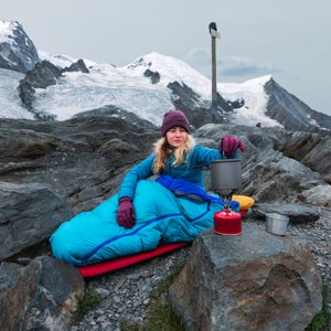 Young woman preparing food outdoors after bivouacking outdoors at La Jonction