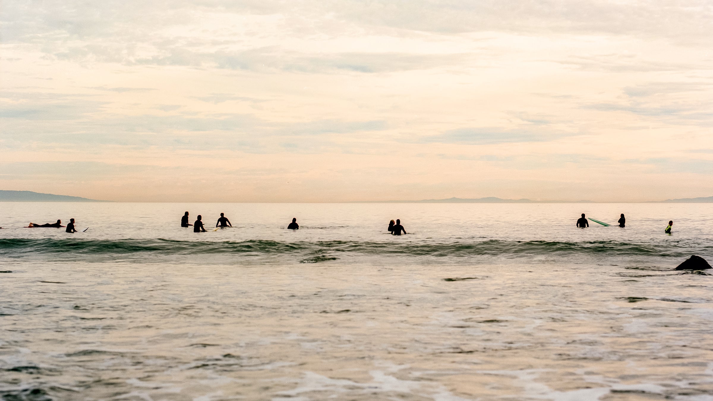 a group of surfers trying to catch a wave
