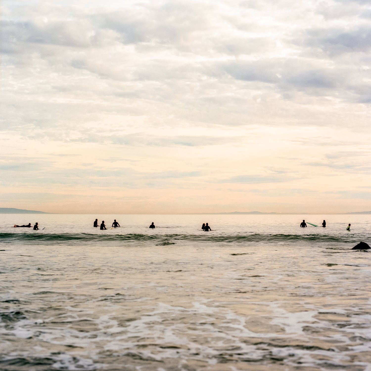 a group of surfers trying to catch a wave