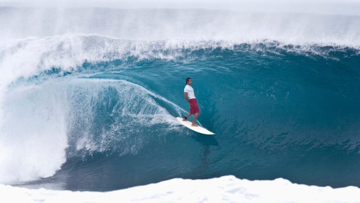 A man surfing a turquoise barrel on Oahu's North Shore