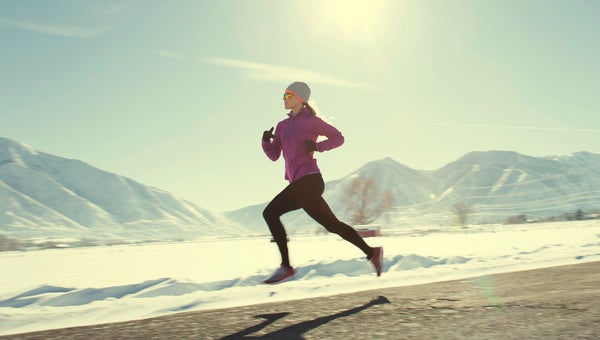 A female runner training for a marathon beats the elements on a cold winter day.