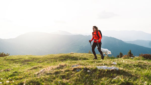 Woman hiking in the mountains with her dog