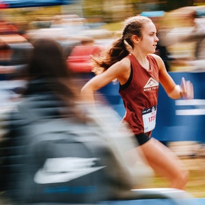 A woman in red runs through a crowd