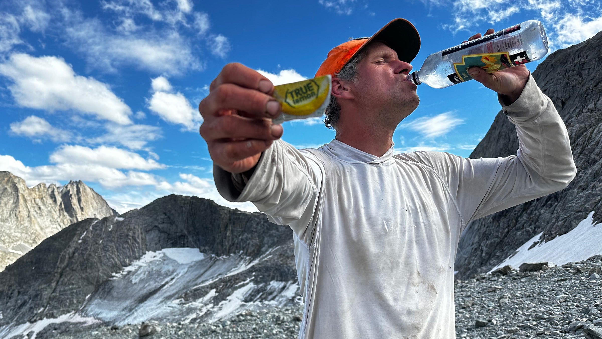 Author Grayson Haver Currin swigs water atop a mountain.