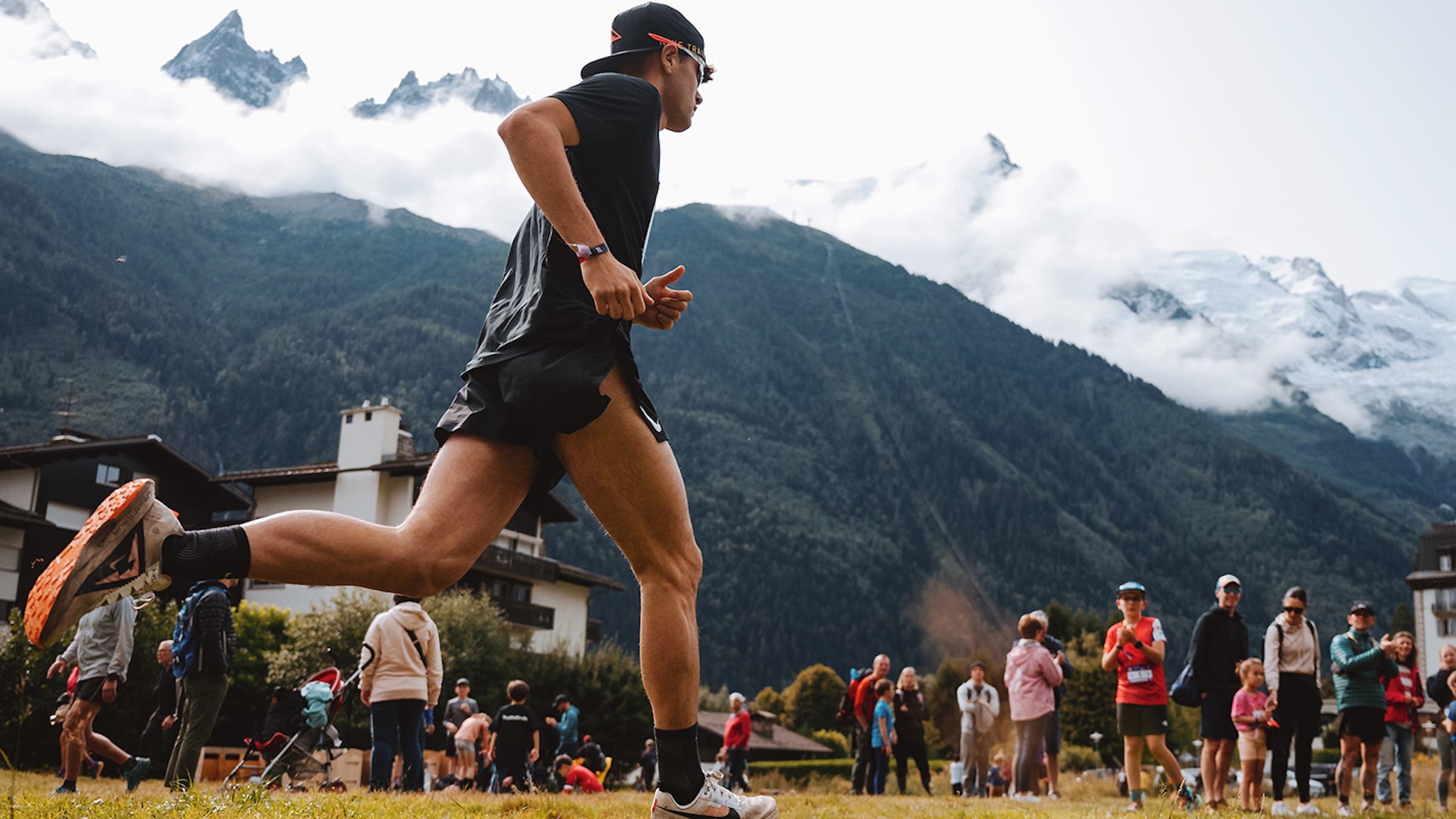 A man finishes a race with a backwards hat on