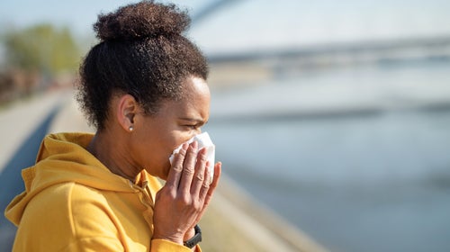 African American mid adult woman sneezing.