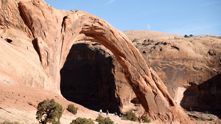 A shot of the 105-foot-tall Corona Arch, whose scale is evident by the scattering of people at its base who look like ants