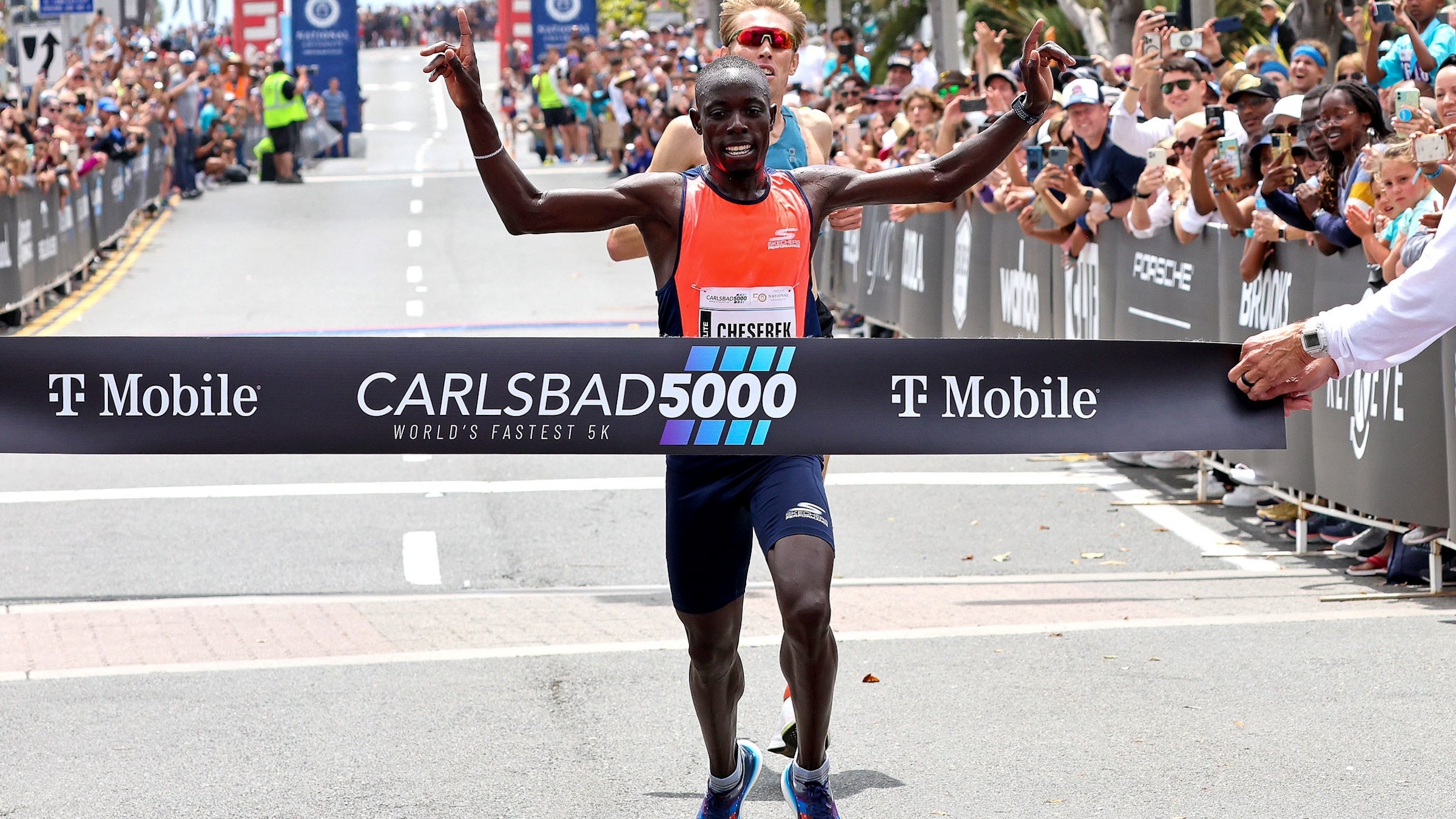 A man crosses the finish line of a 5K