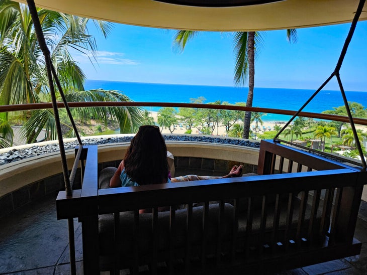 Woman on swing looking at ocean