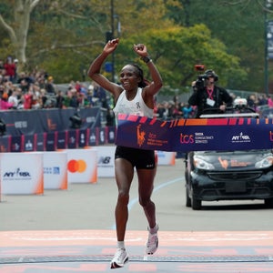 a woman in white shoes and singlet wins the nyc marathon
