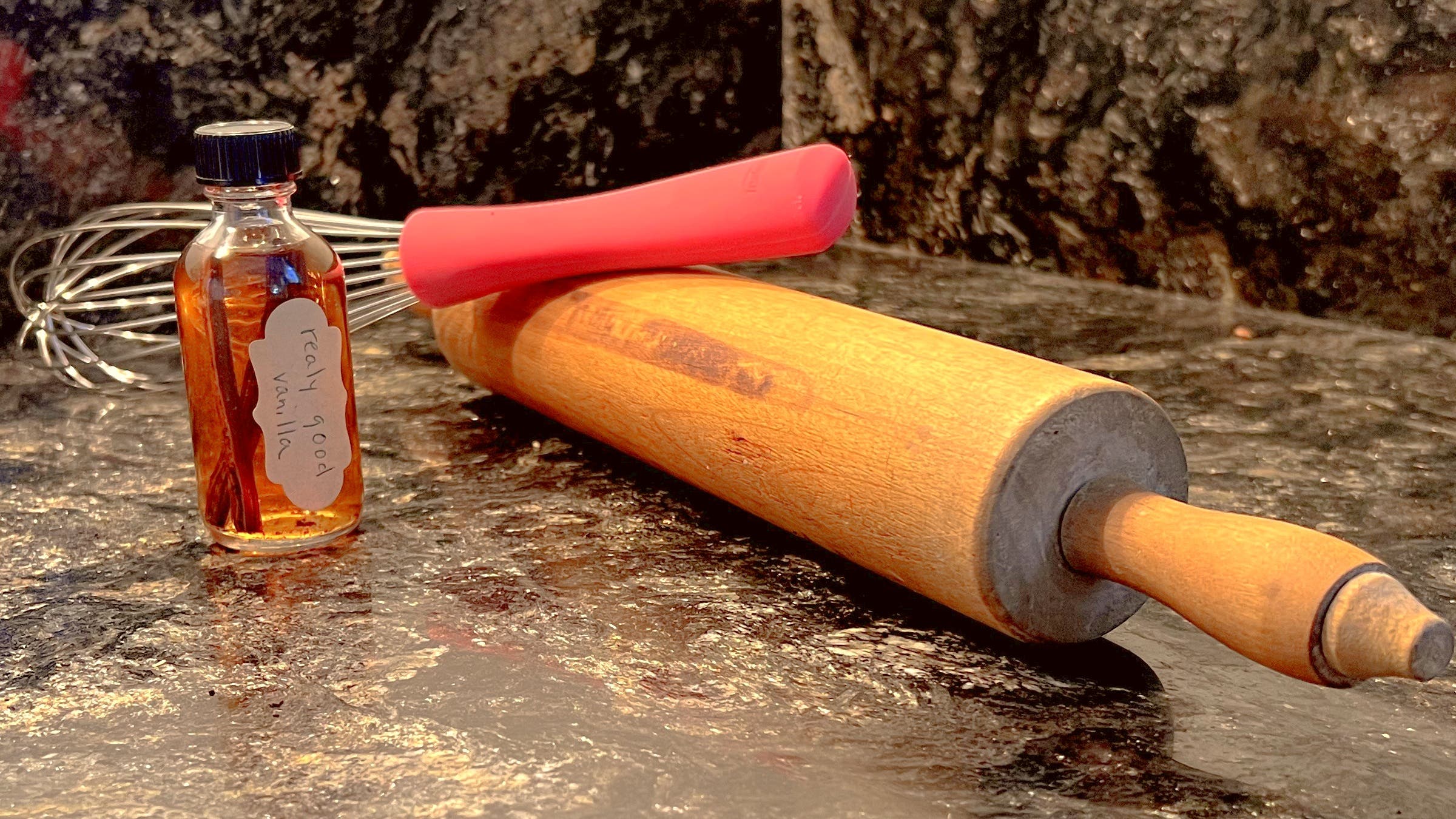 Homemade vanilla extract with rolling pin and whisk