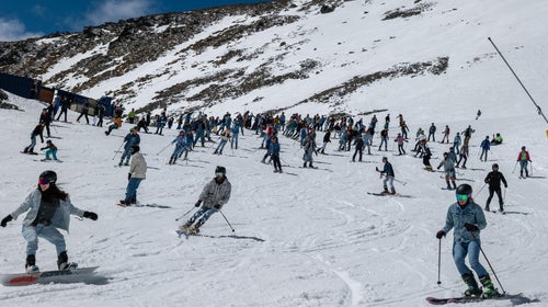 dozens of skiers and snowboarders wearing jeans