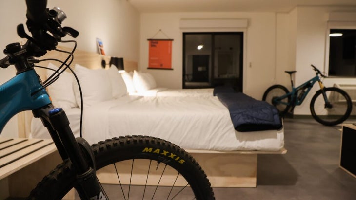 A guest room with two queen beds and two bikes parked in there as well