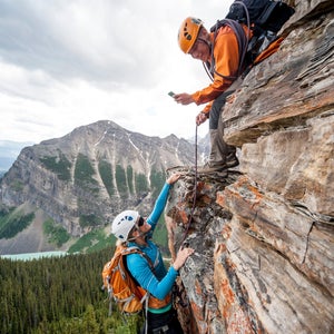 Climber takes picture of teammate ascending cliff