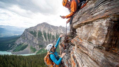 Climber takes picture of teammate ascending cliff