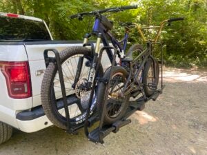 Mountain bike and BMX bike loaded on Kuat Piston Pro rack on back of pickup truck