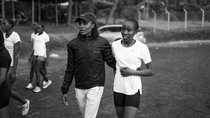 Two runner women hold each other and smile