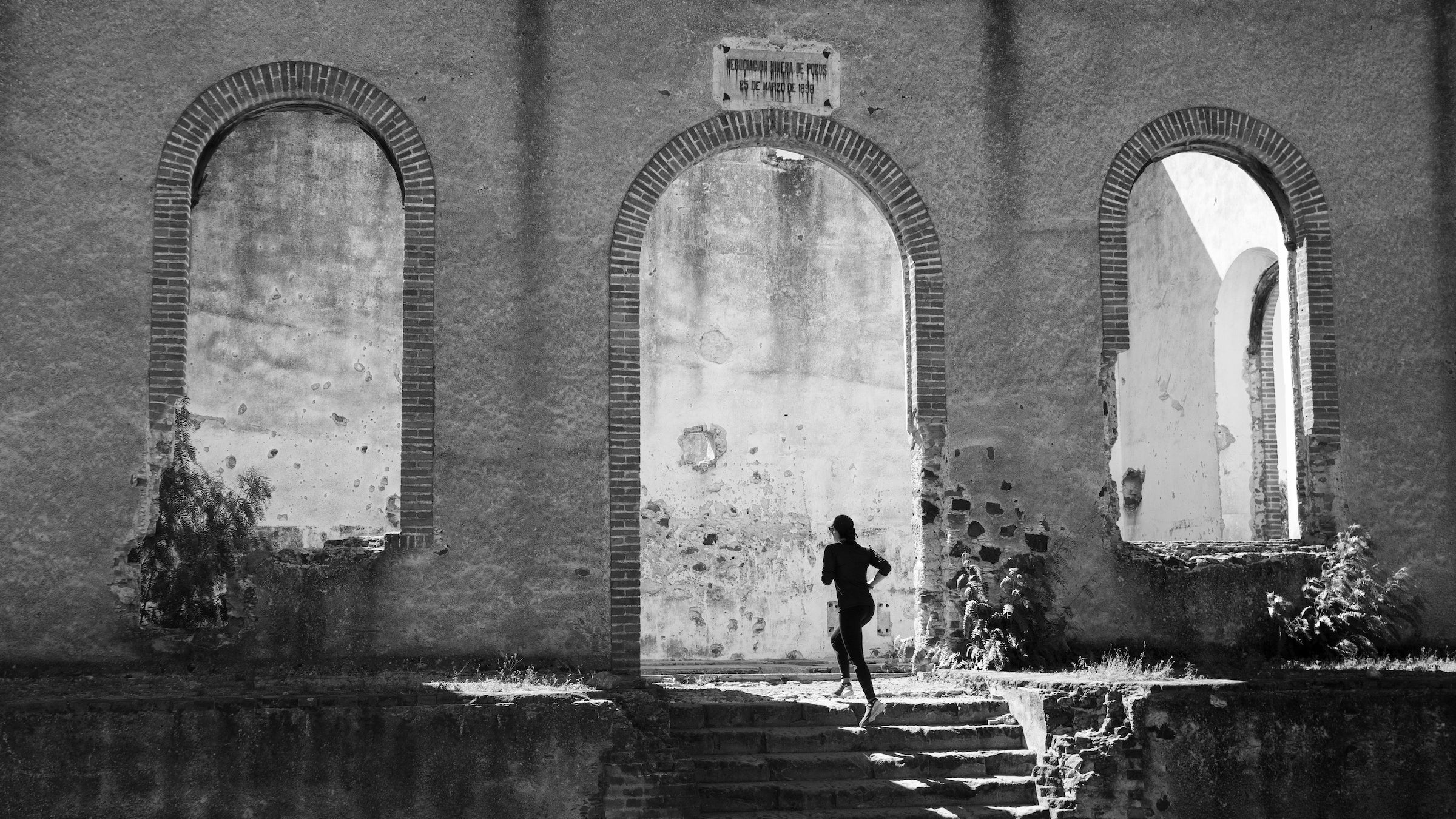 Woman running up the stairs at the ruins of Santa Brigida Hacienda