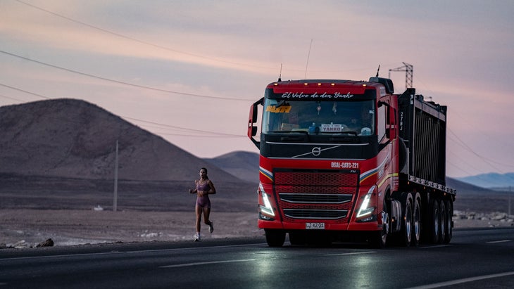 A runner follows a dry road in the Chilean desert