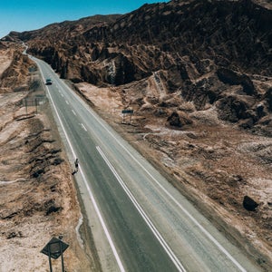 A runner follows a dry road in the Chilean desert