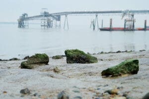 A rocky river shore on an overcast day of mudlarking.