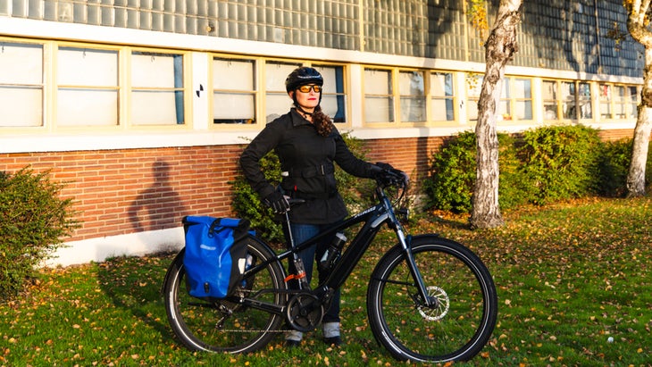 woman wearing helmet standing with electric bike