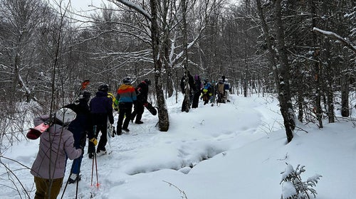 Skiers hike out of the woods near Killington, Vermont.