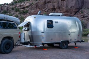 Airstream trailer attached to truck parked in canyon