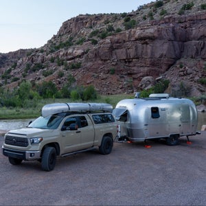 Toyota truck with Airstream trailer parked in canyon.